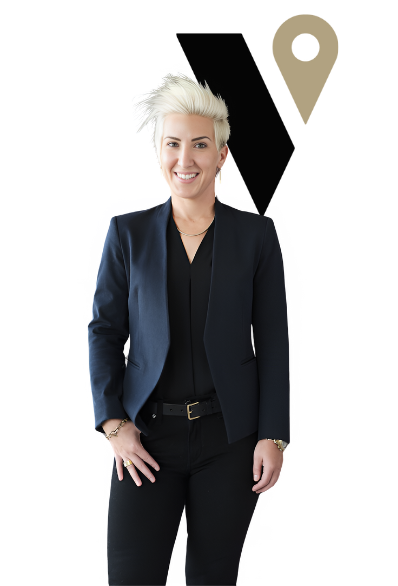 Person in a dark blazer standing in front of a black and gold logo on a white background