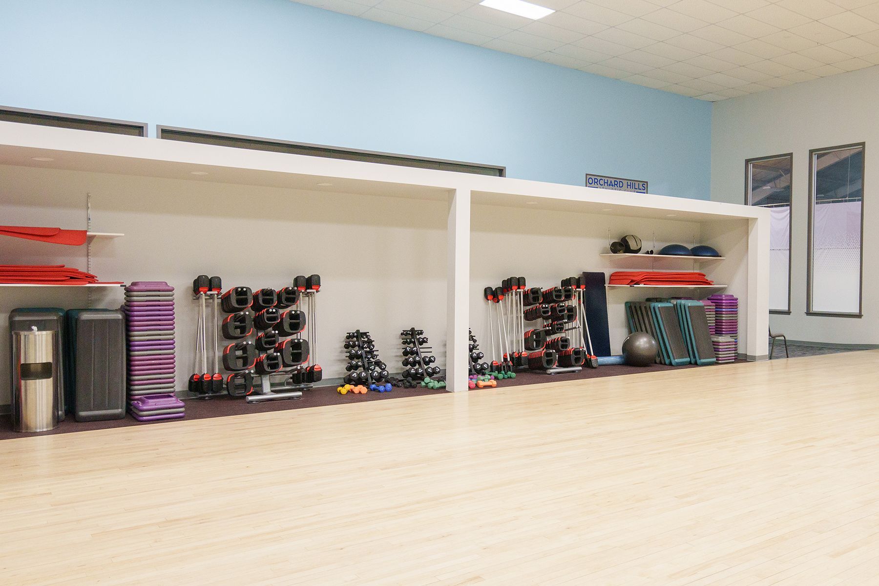 A gym with a lot of exercise equipment on the floor.