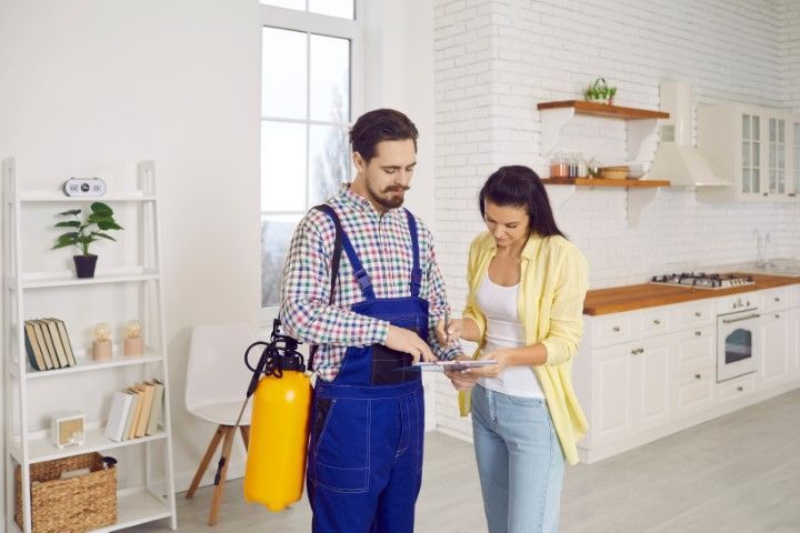 Two people in a bright kitchen inspecting a yellow fire extinguisher together