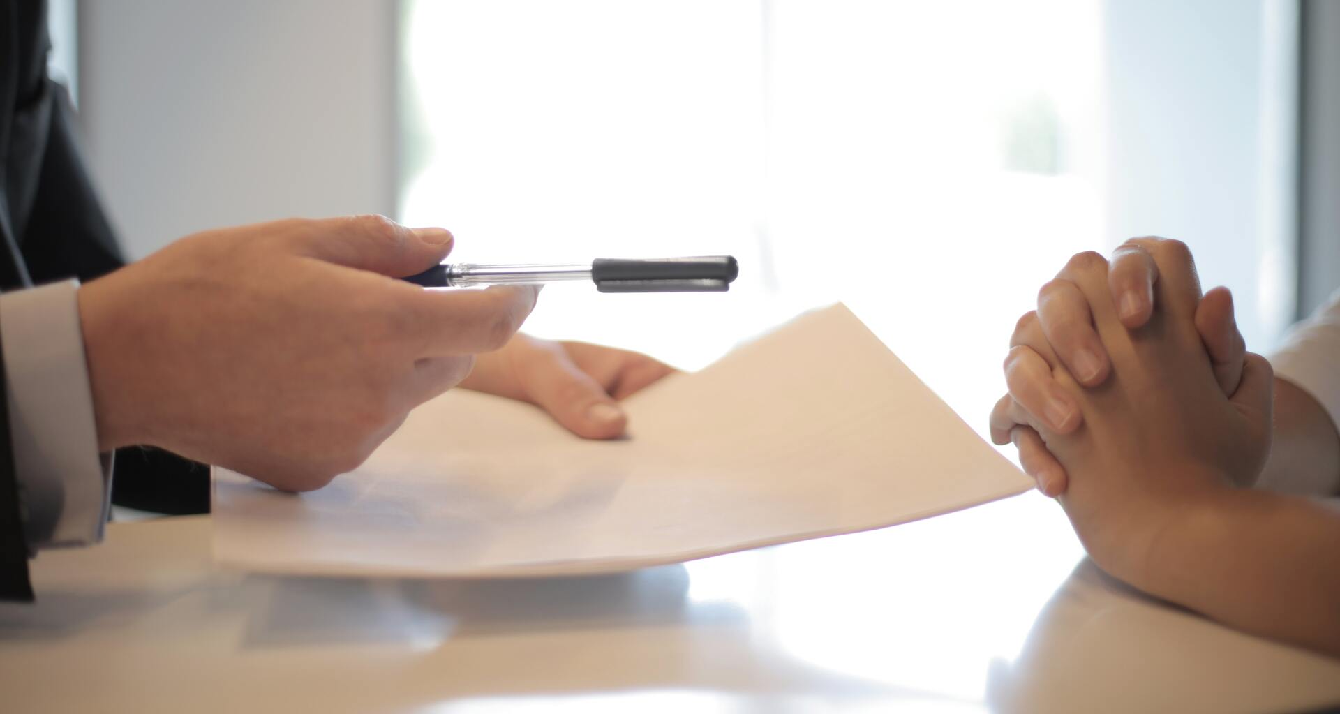 A man is giving a piece of paper to a woman.