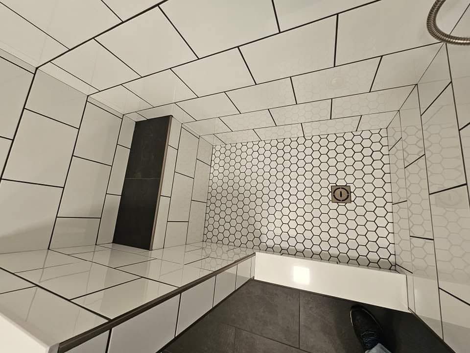 White tiled geometric room with a black doorway and a honeycomb-pattern wall light.