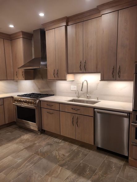 Modern kitchen with dark wood cabinets, stainless steel appliances, granite counters, and tiled backsplash. Modern kitchen with dark wood cabinets, stainless steel appliances, granite counters, and tiled backsplash.