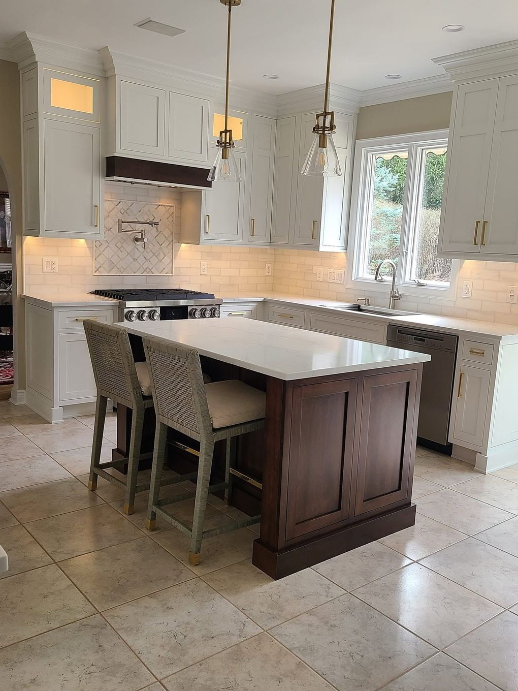 Modern kitchen with a large island, white cabinets, beige tile floor, and two barstools Modern kitchen with a large island, white cabinets, beige tile floor, and two barstools