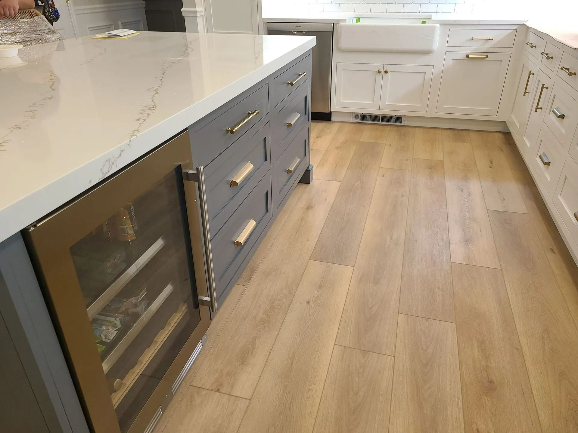 Modern kitchen with white countertops, gray cabinets, and light wood floors