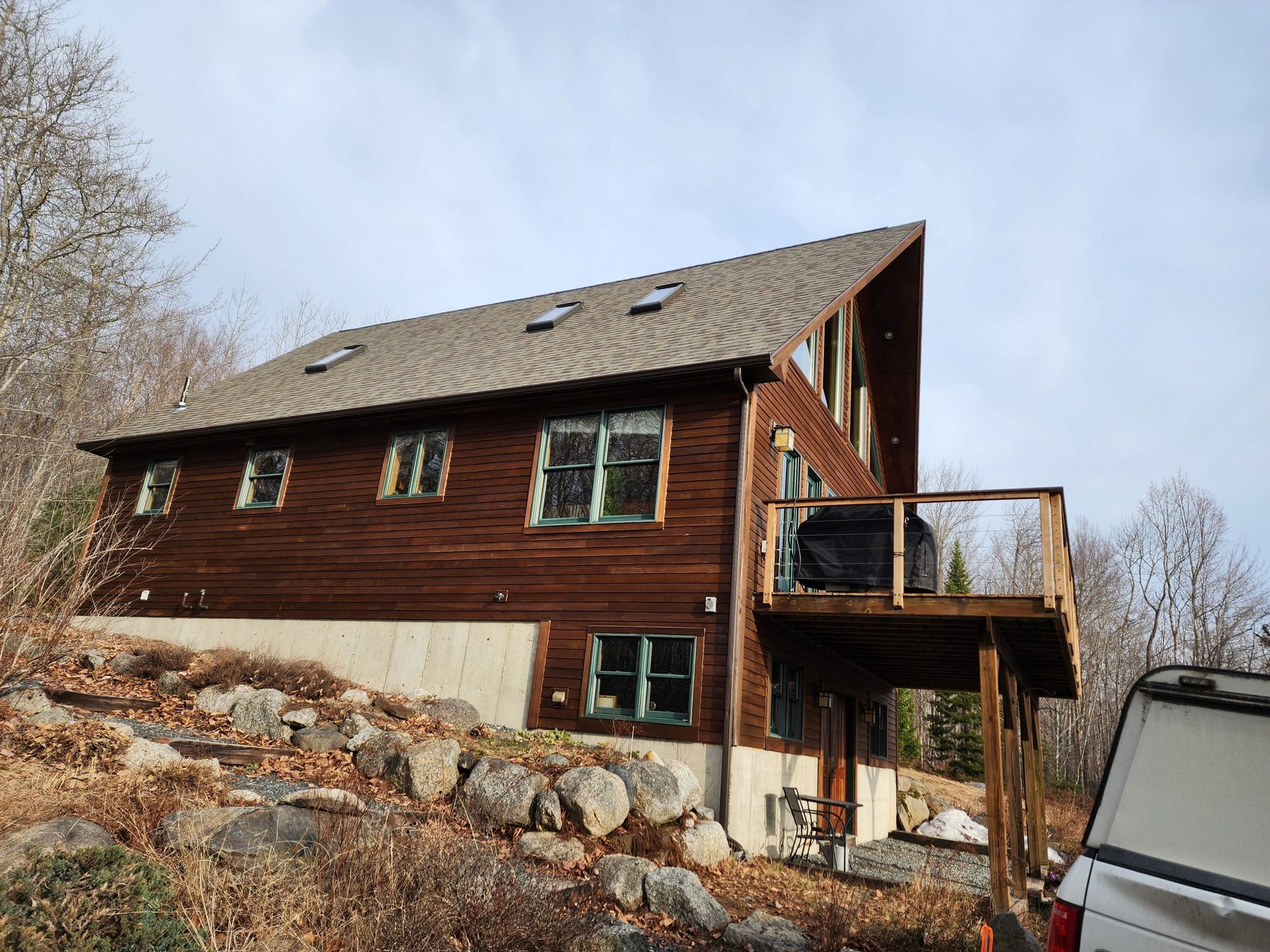 A large wooden house with a car parked in front of it.