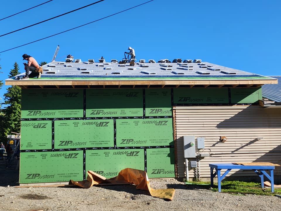 A man is working on the roof of a house.