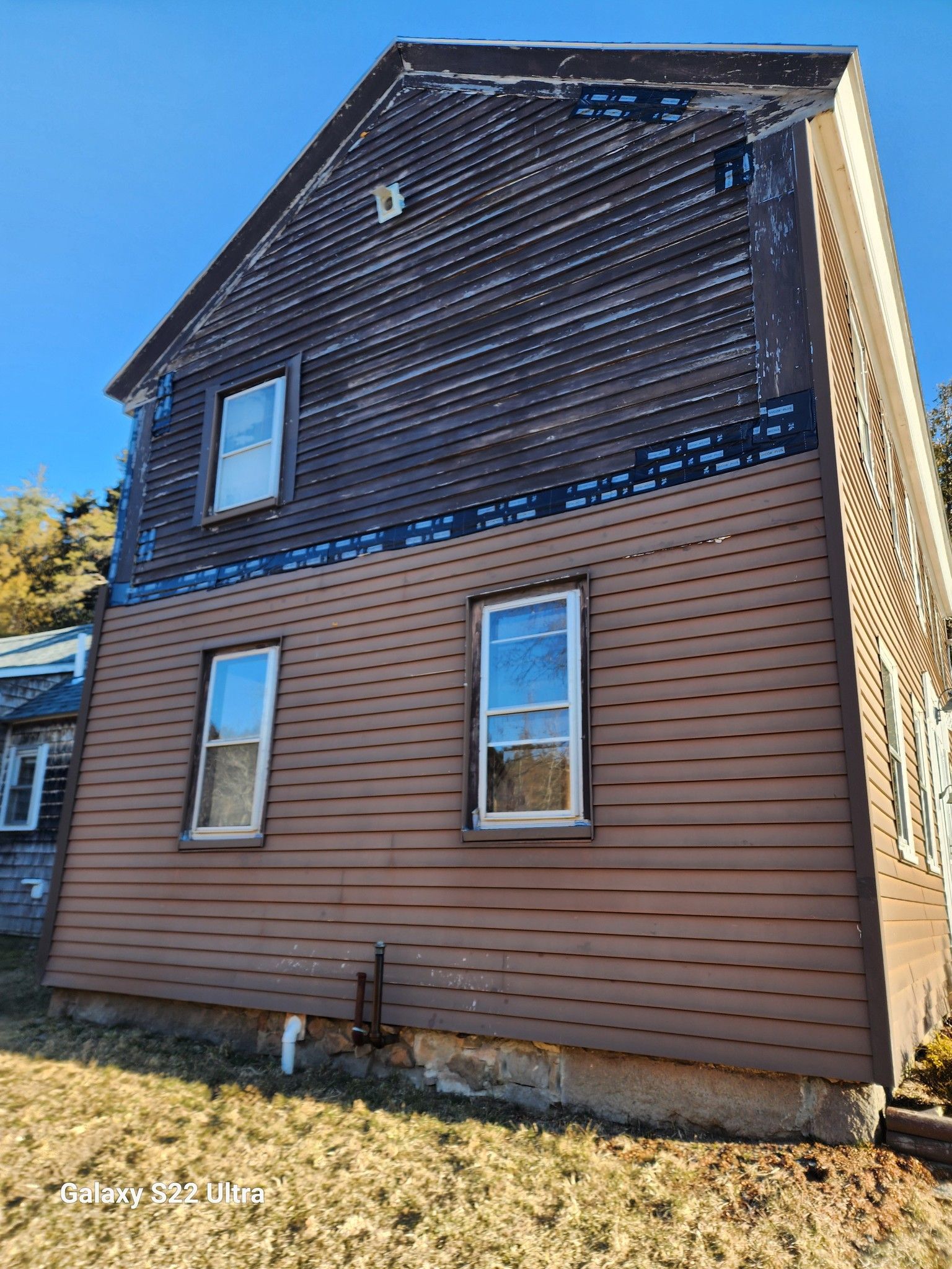 A house with a lot of windows and a blue sky in the background.
