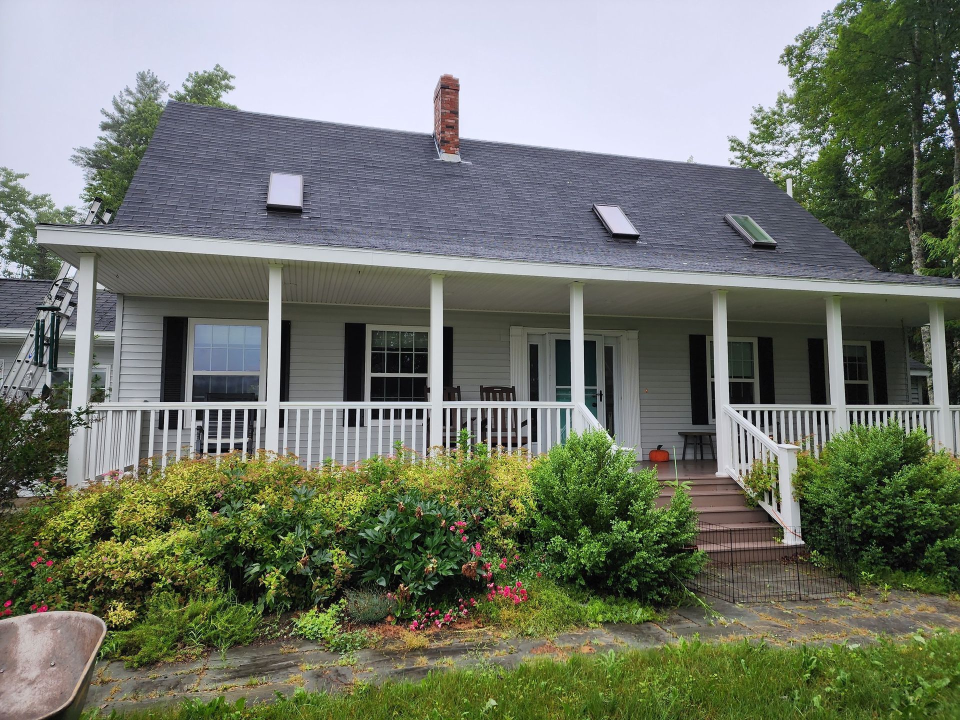 A white house with a black roof and a porch