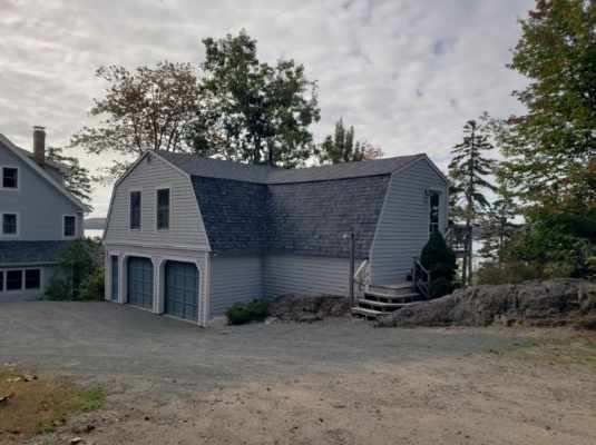 A large house with a garage and stairs in front of it.