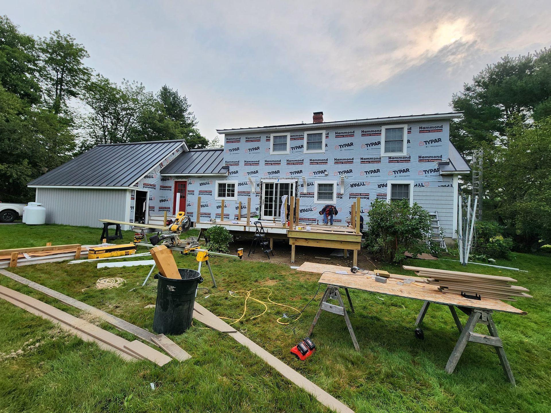 A house is being remodeled and a wooden deck is being built in the backyard.