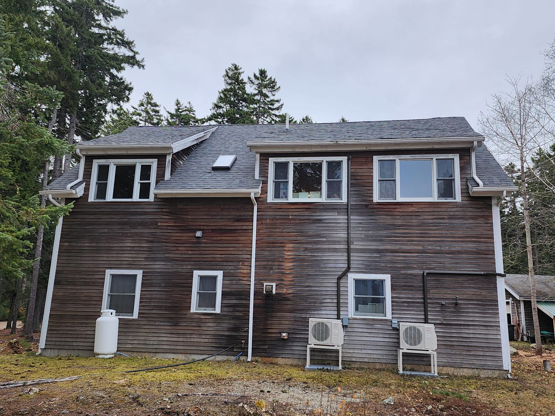A large wooden house with a gray roof and a lot of windows