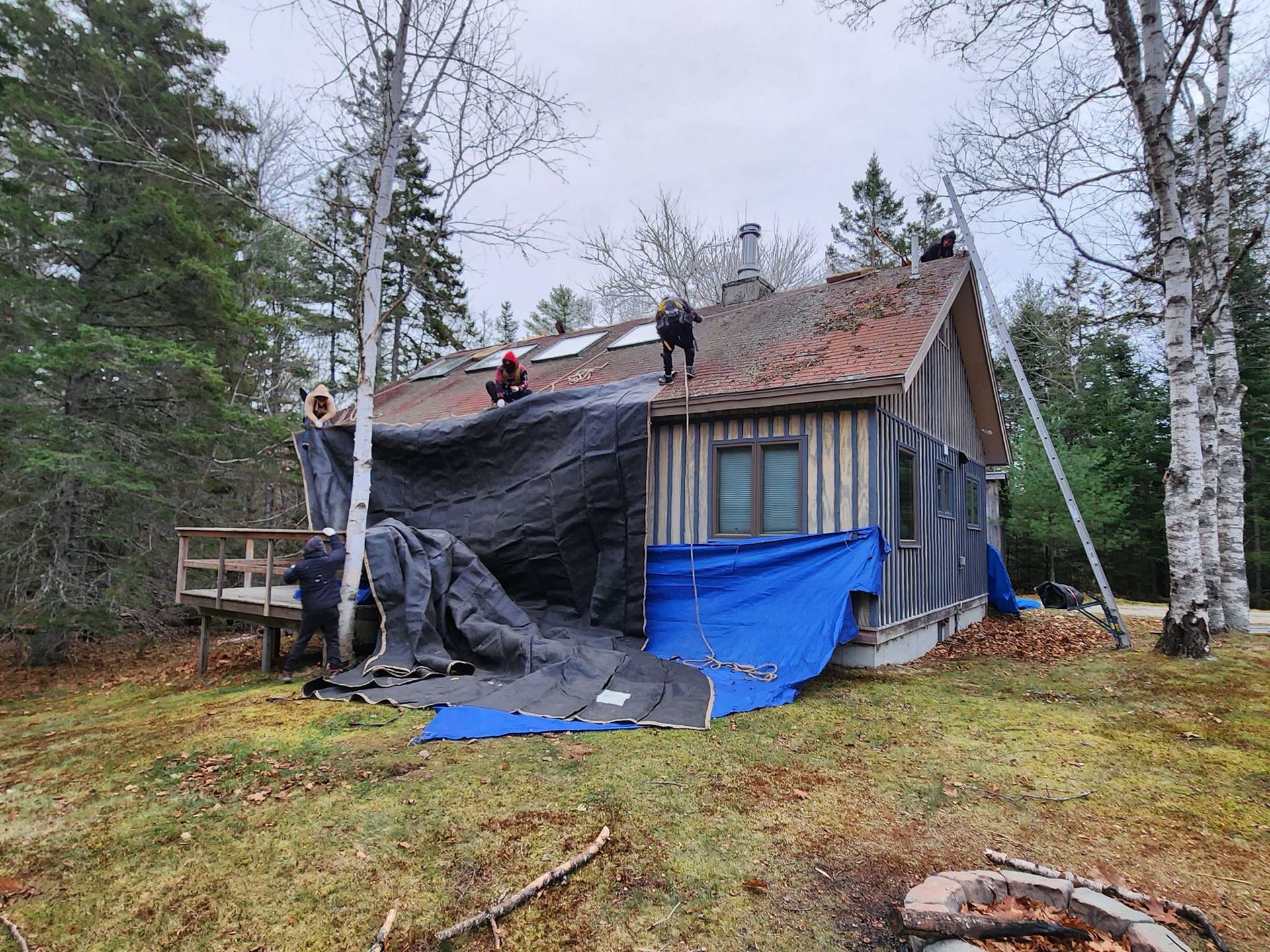 A group of people are working on the roof of a house.