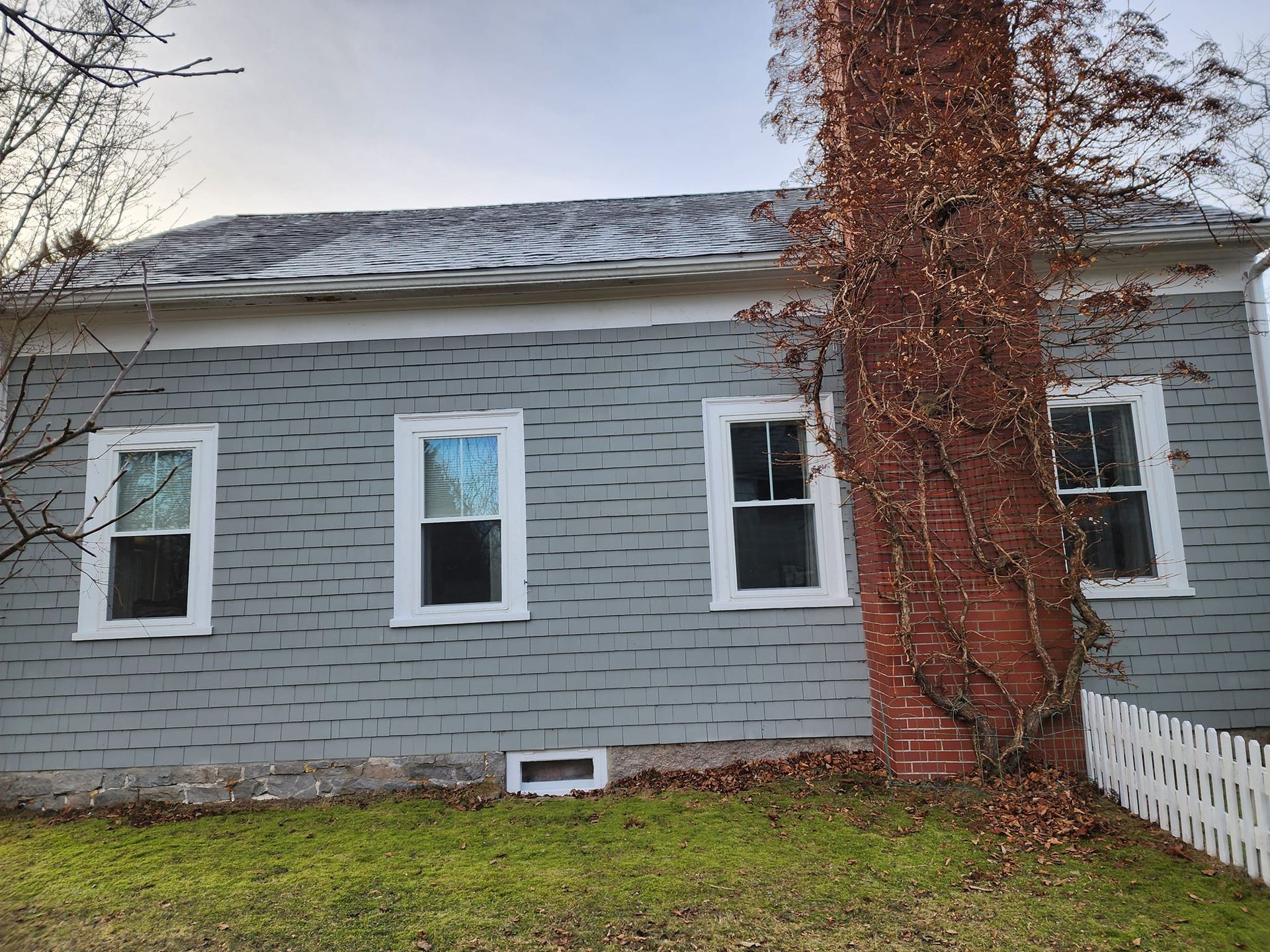 A house with a chimney and a tree in front of it