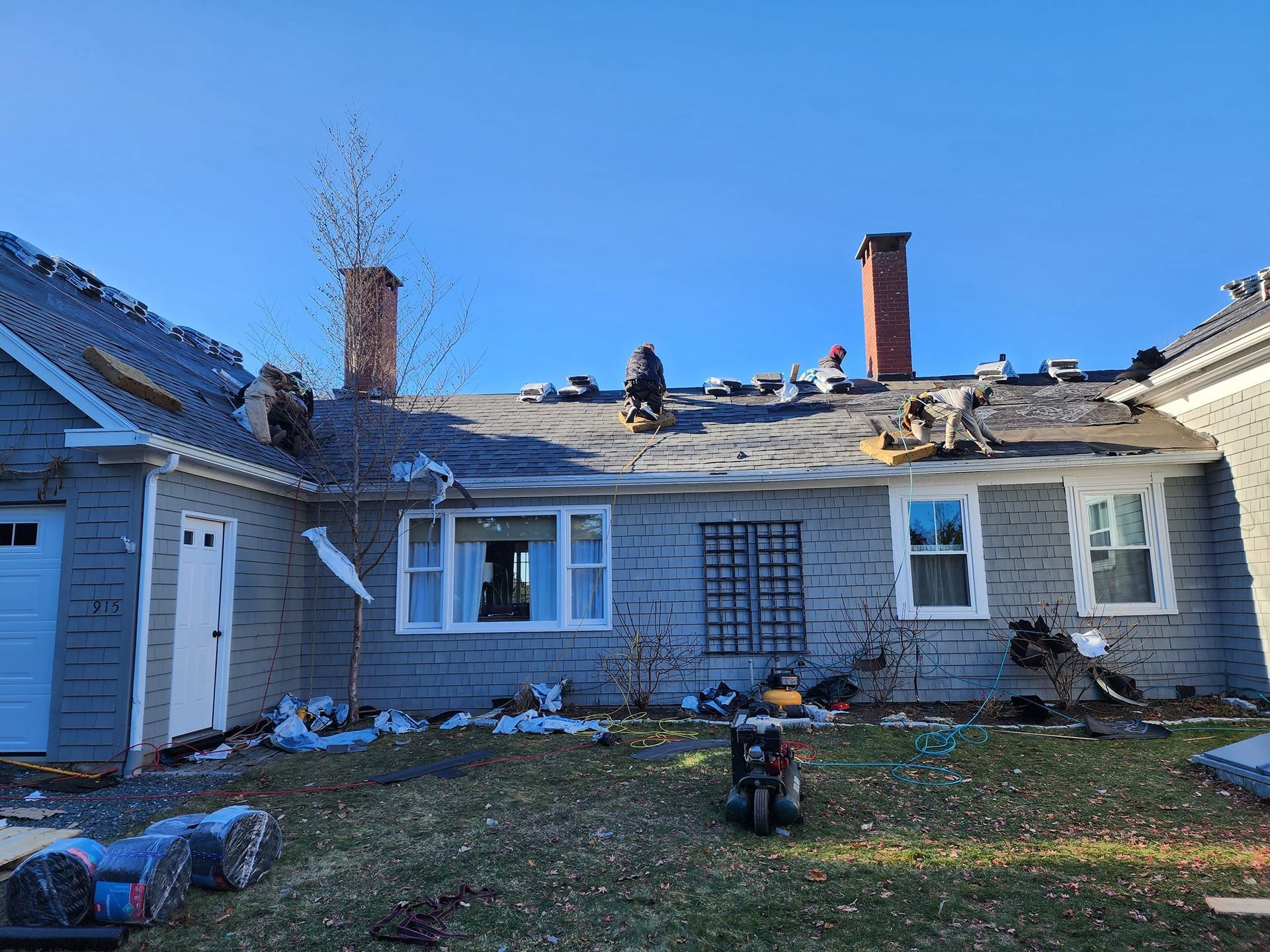A house is being remodeled with a motorcycle parked in front of it.