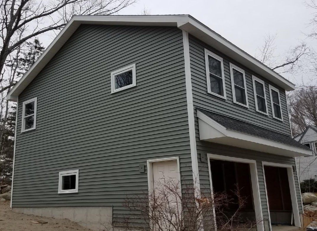 A house with a green siding and a white trim
