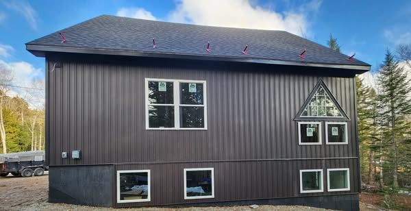 A large house with a lot of windows on the side of it.