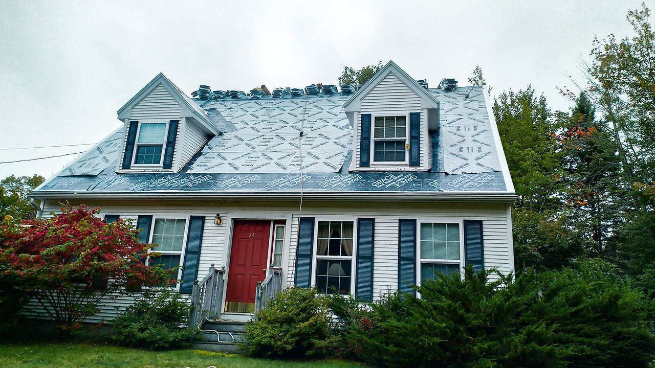 A white house with blue shutters and a red door
