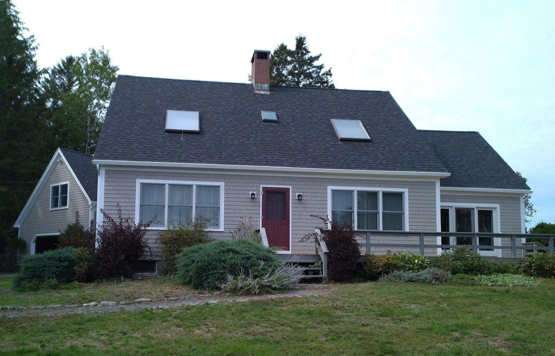 A house with a black roof and a red door