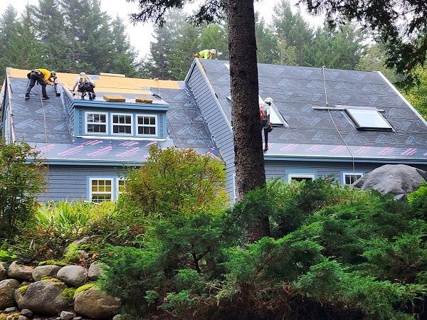 Two men are working on the roof of a house