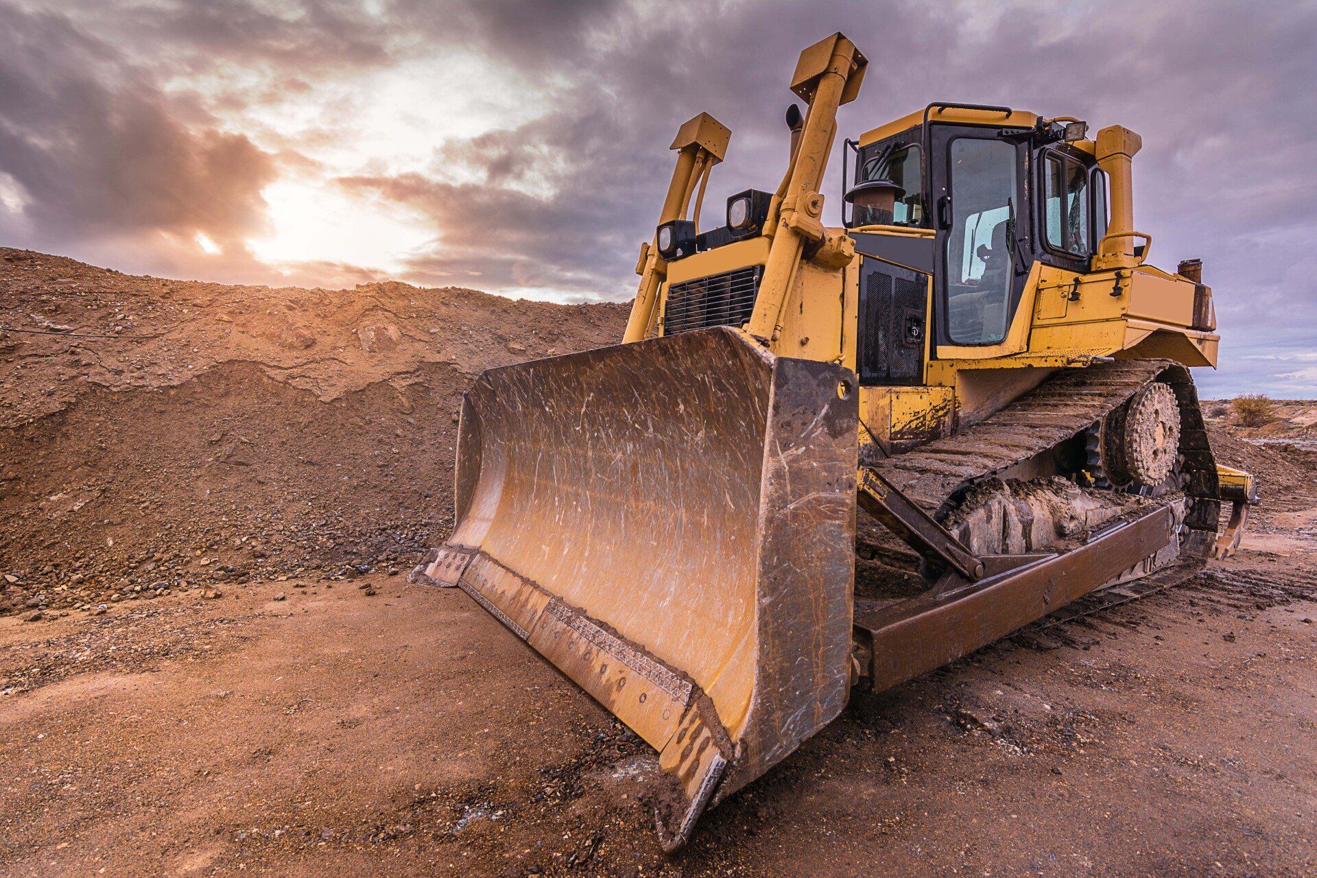 Un bulldozer est assis sur un champ de terre.