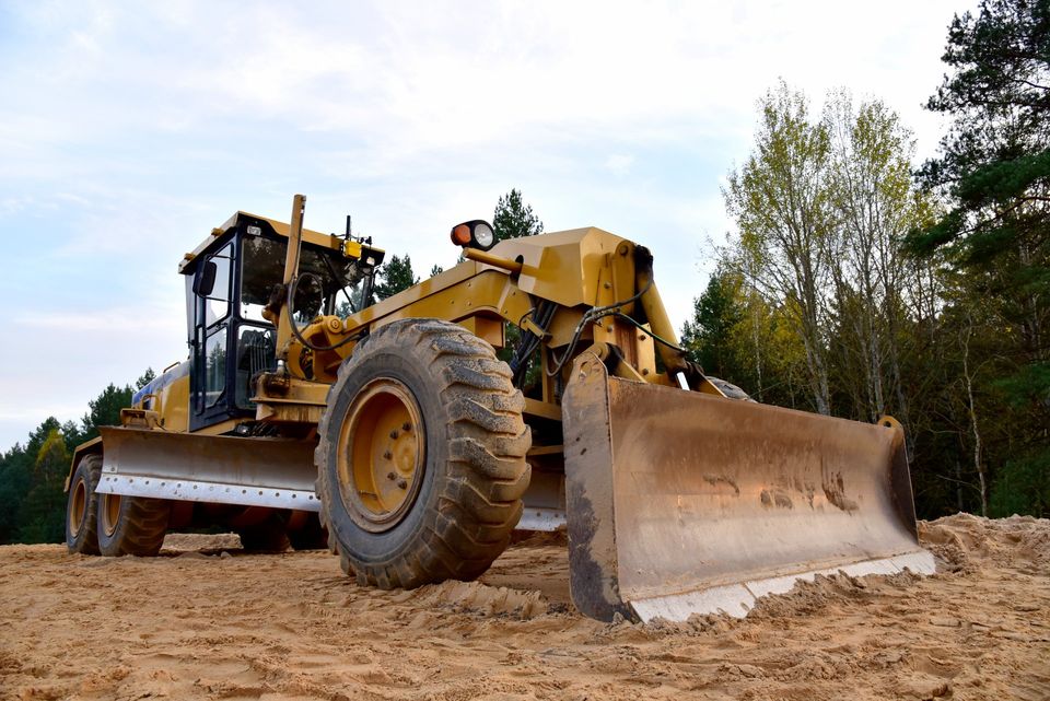 Un bulldozer est assis sur un champ de terre.