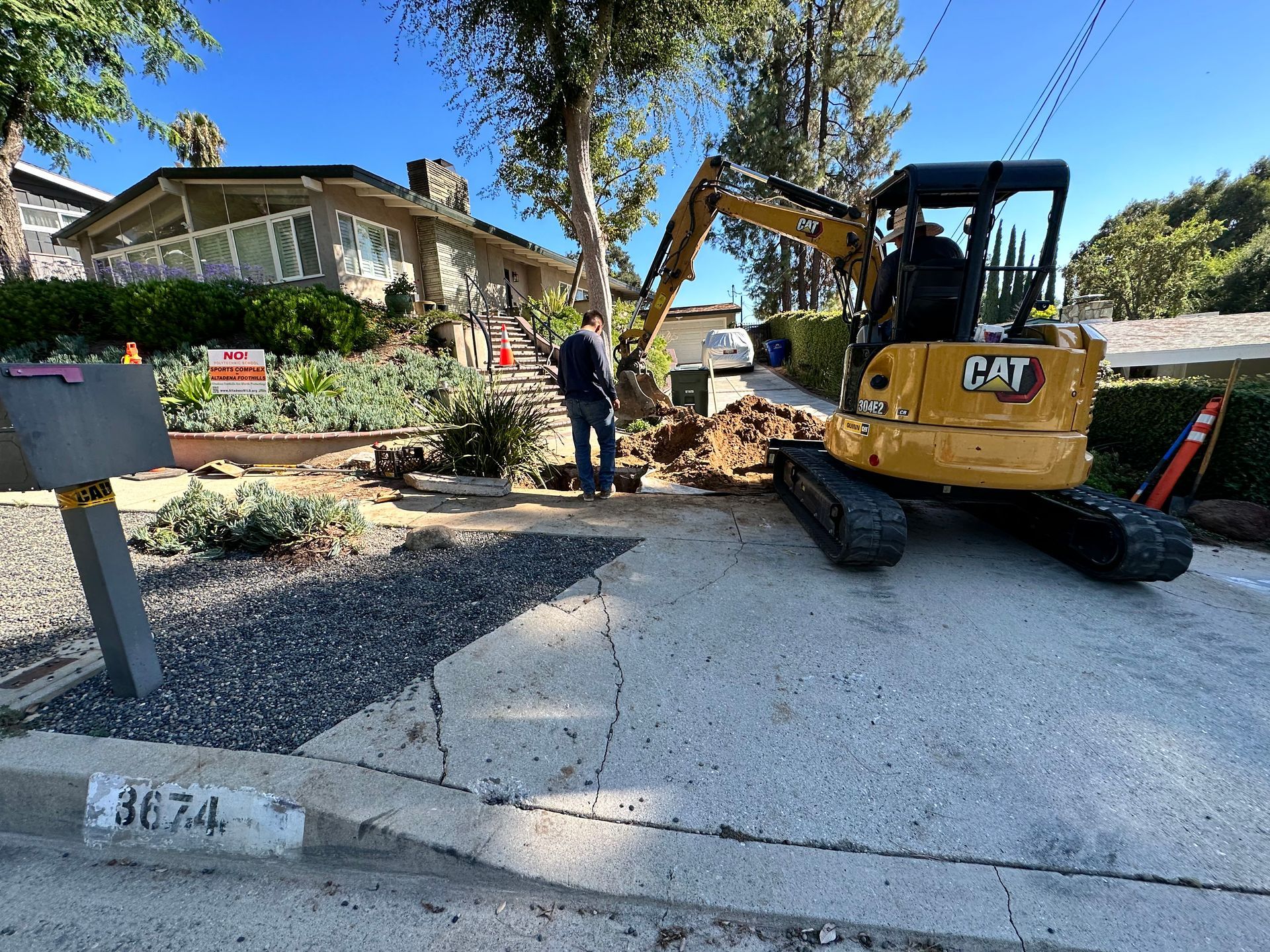 Excavator exposing sewer pipe for repair.