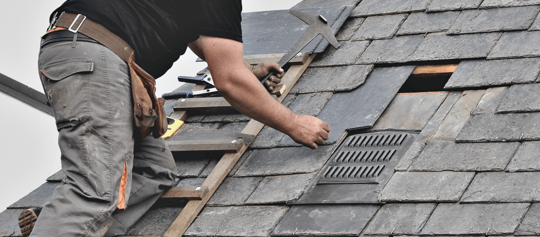 A man is working on the roof of a house.
