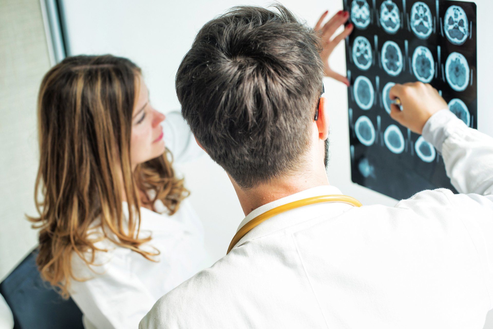 Due professionisti medici esaminano le immagini di una scansione cerebrale.