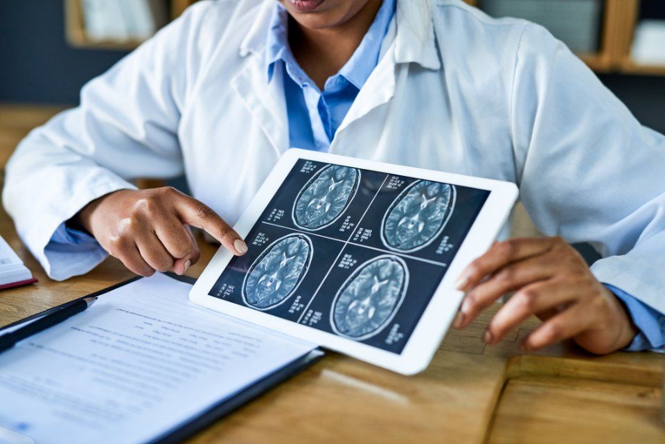 Il medico indica le immagini della scansione cerebrale su un tablet.