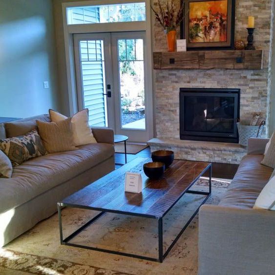A living room with a couch a custom coffee table and a fireplace