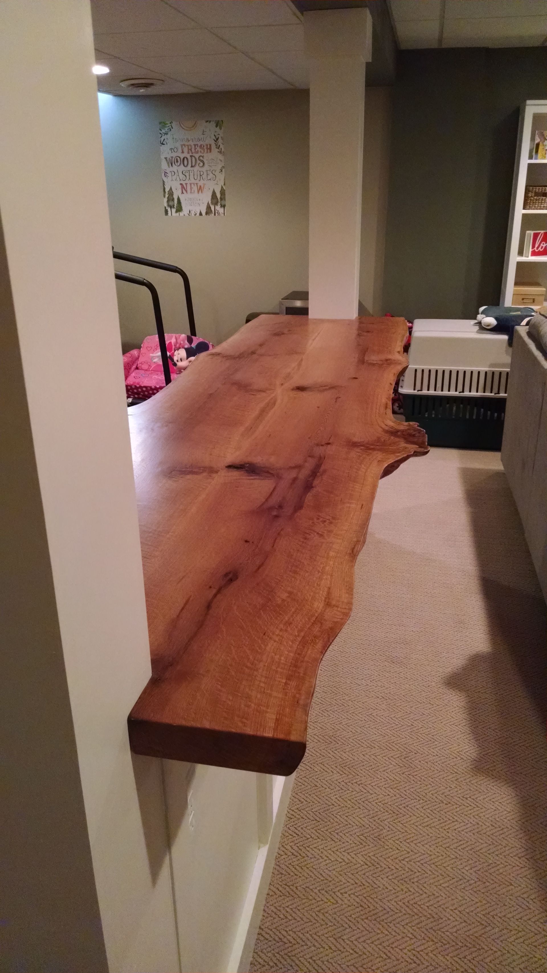 A locally made wooden shelf is hanging on a wall in a room.