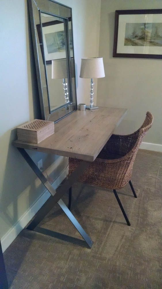 A custom made desk with a chair and a mirror in a room.