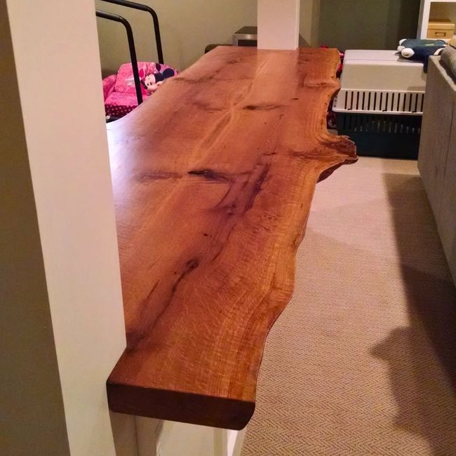 A wooden table is sitting in a room next to a wall.