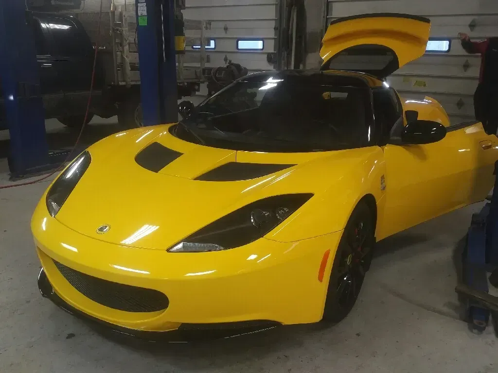 Yellow Sports Car with Open Doors in a Garage | Hippensteel Auto Inc.