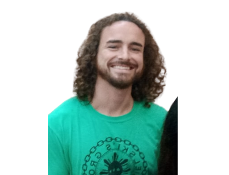 A man with curly hair and a beard wearing a green shirt