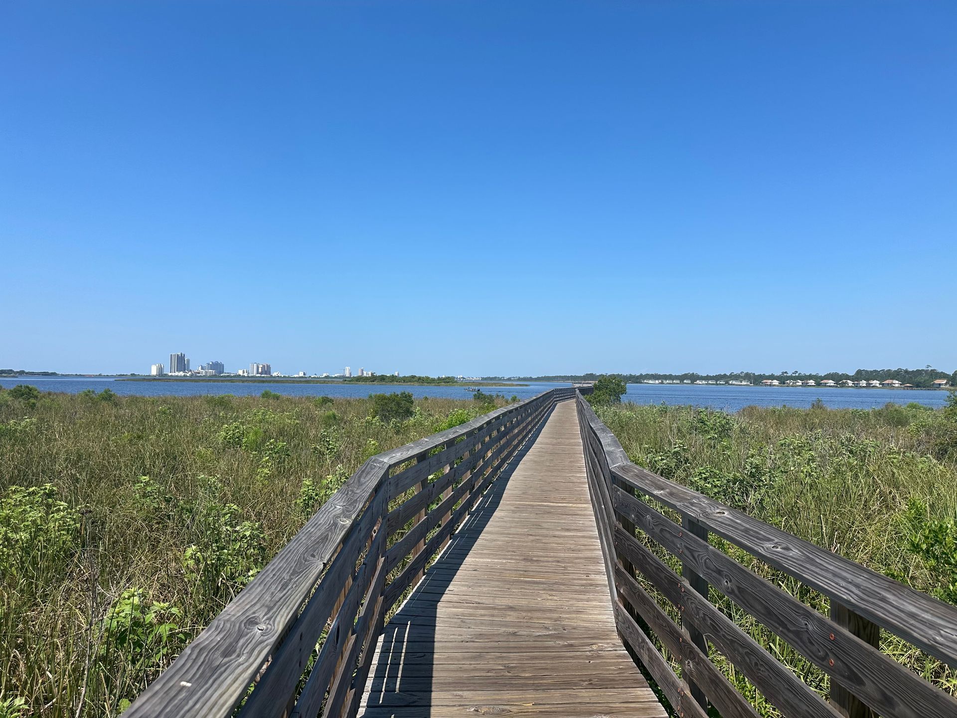 A wooden walkway leading to a body of water.