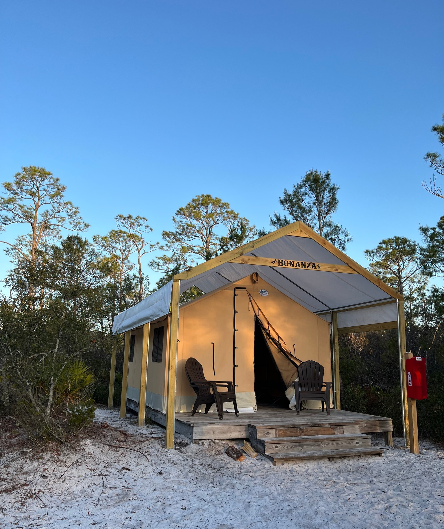A tent with a canopy and chairs on the porch