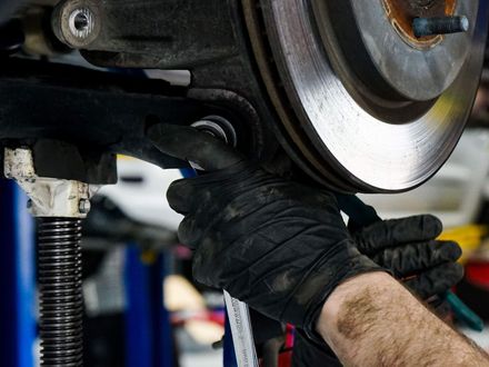 Mechanic using a wrench on car suspension | EuroSense