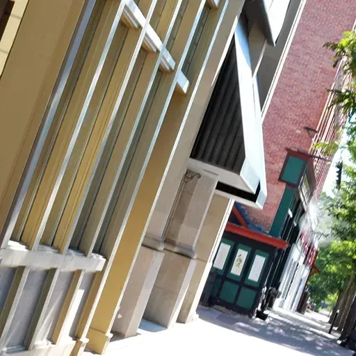 Empty city alley with tilted view of beige and brick building facades on a sunny day