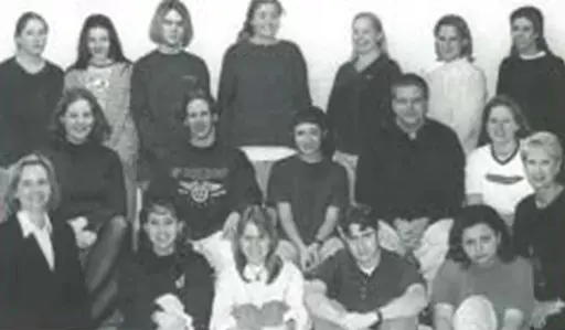 Black-and-white group portrait of people posed indoors in three rows