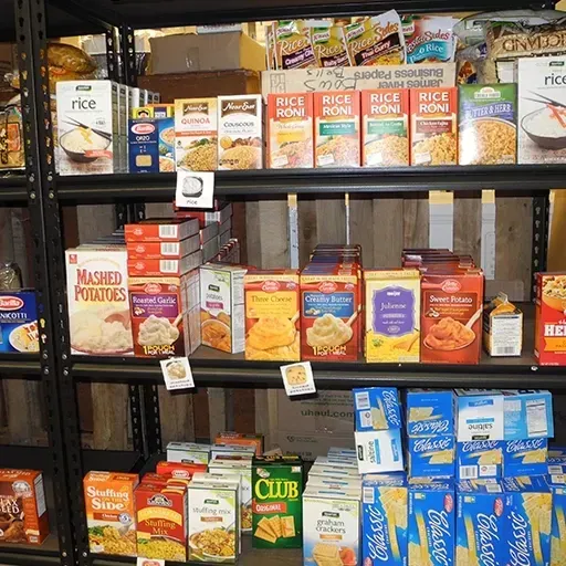 Grocery shelf with assorted boxed rice, mashed potatoes, stuffing, and other packaged side dishes.