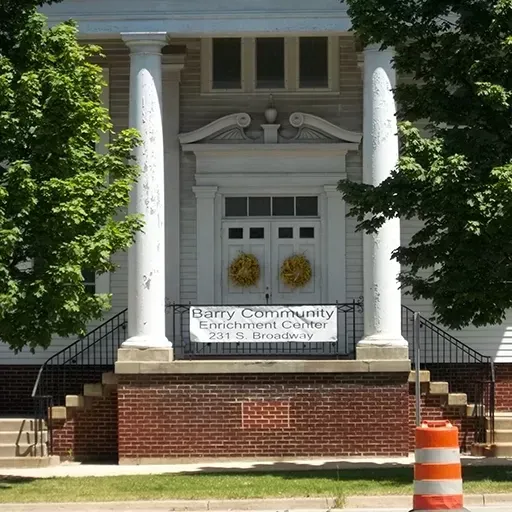 Barry Community Enrichment Center entrance with white columns, brick steps, and orange traffic barrel