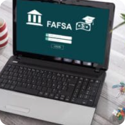 Laptop displaying FAFSA login screen on a desk