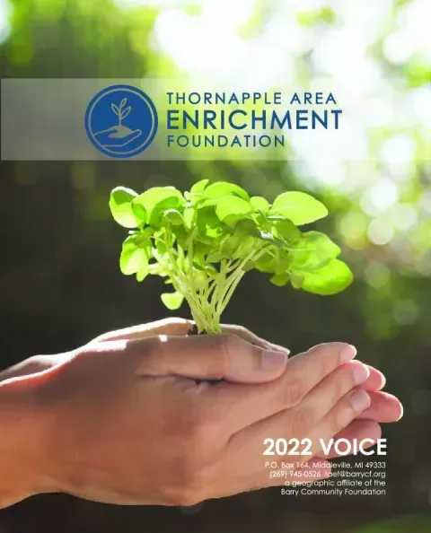 Hands holding a small green seedling with Thornapple Area Enrichment Foundation logo and “2022 VOICE” text.