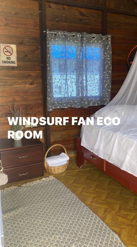 A bedroom in a wooden cabin with a bed and a window.