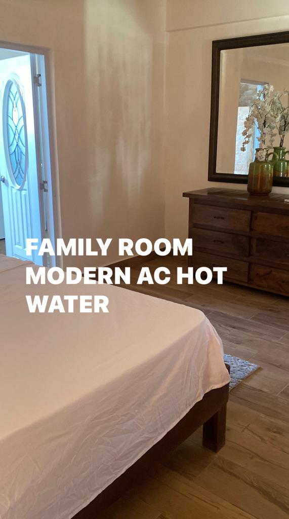 A bedroom with a bed and dresser and the words family room modern ac hot water