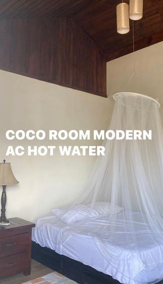 A bedroom with a canopy bed and the words coco room modern ac hot water