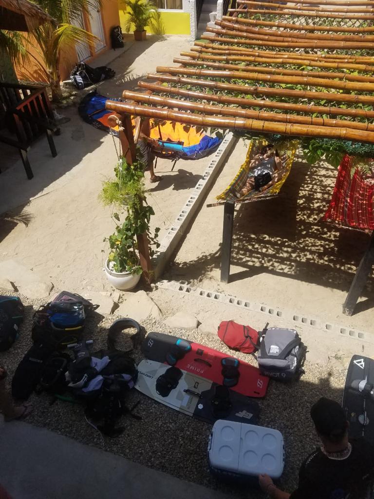 A group of people are sitting under a wooden pergola