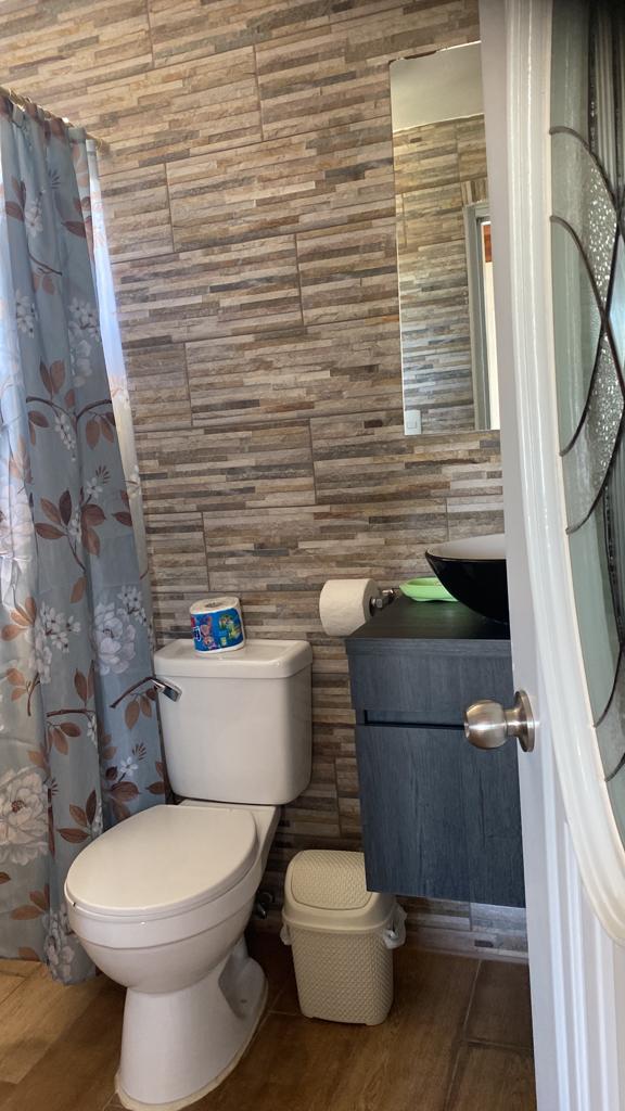 A bathroom with a toilet , sink , and shower curtain.