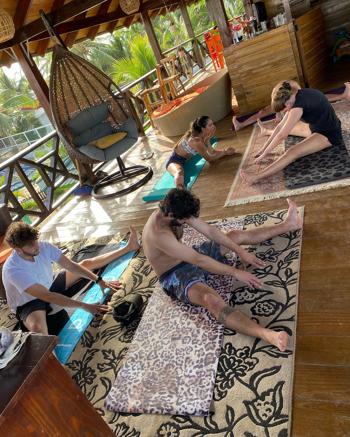 A group of people are sitting on yoga mats in a room.